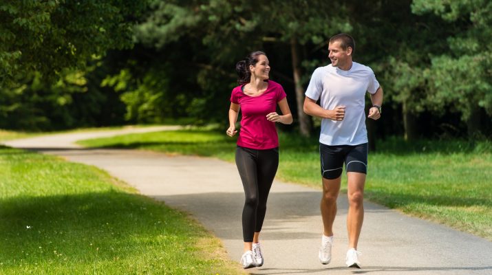 Cheerful Caucasian couple friends running in park